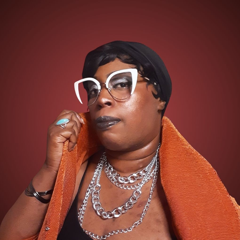 a black person with black short hair in a bob cut, medium brown skin, and white cat eye glasses.